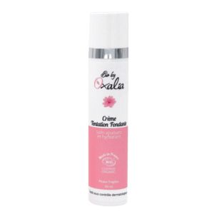 Valerie Millet Una botella blanca y rosa de "Crème Tentation Fondante" de Oxalia, con un diseño floral y un dosificador. Bienestar Holistico